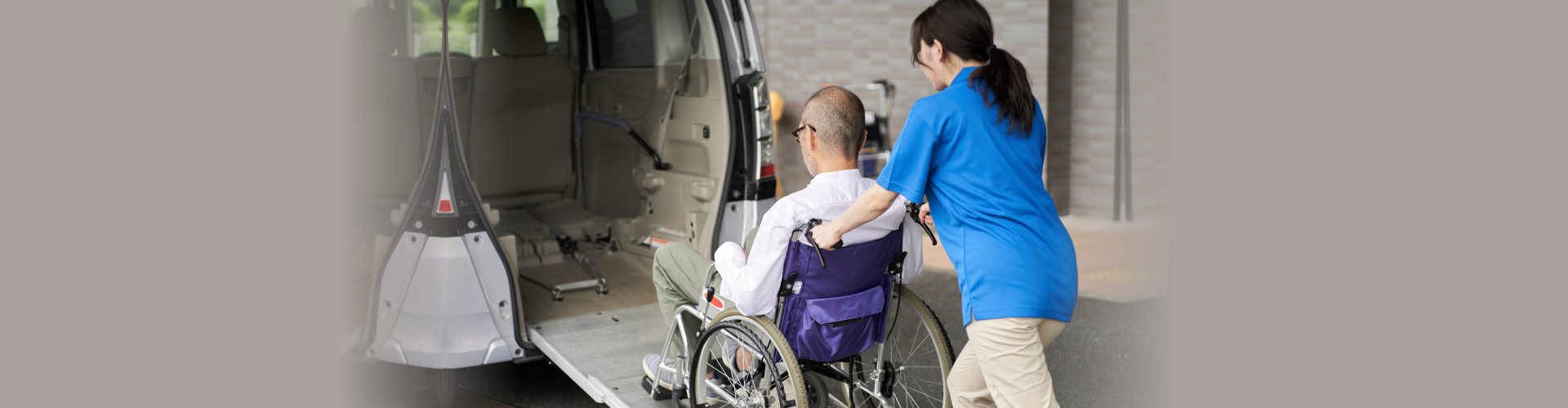 caregiver assisting a senior to get into a car