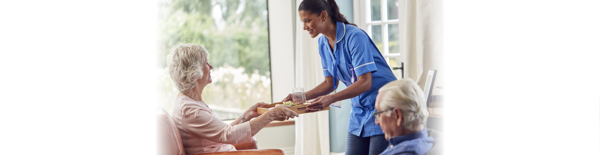 caregiver giving a food to a senior woman