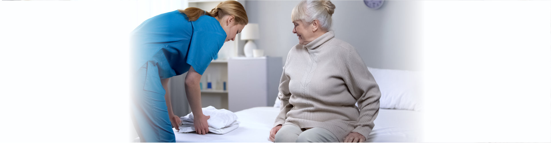 senior watching a caregiver folding a blanket