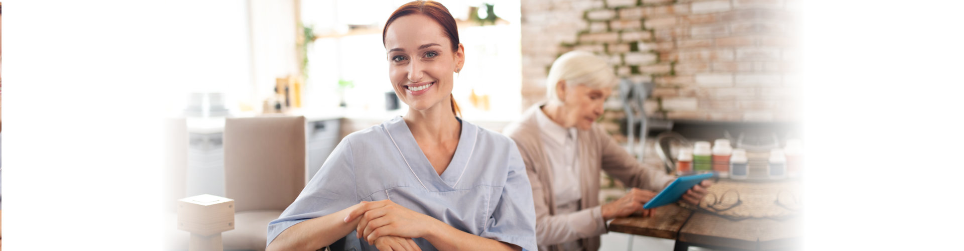 caregiver smiling and a senior reading a book